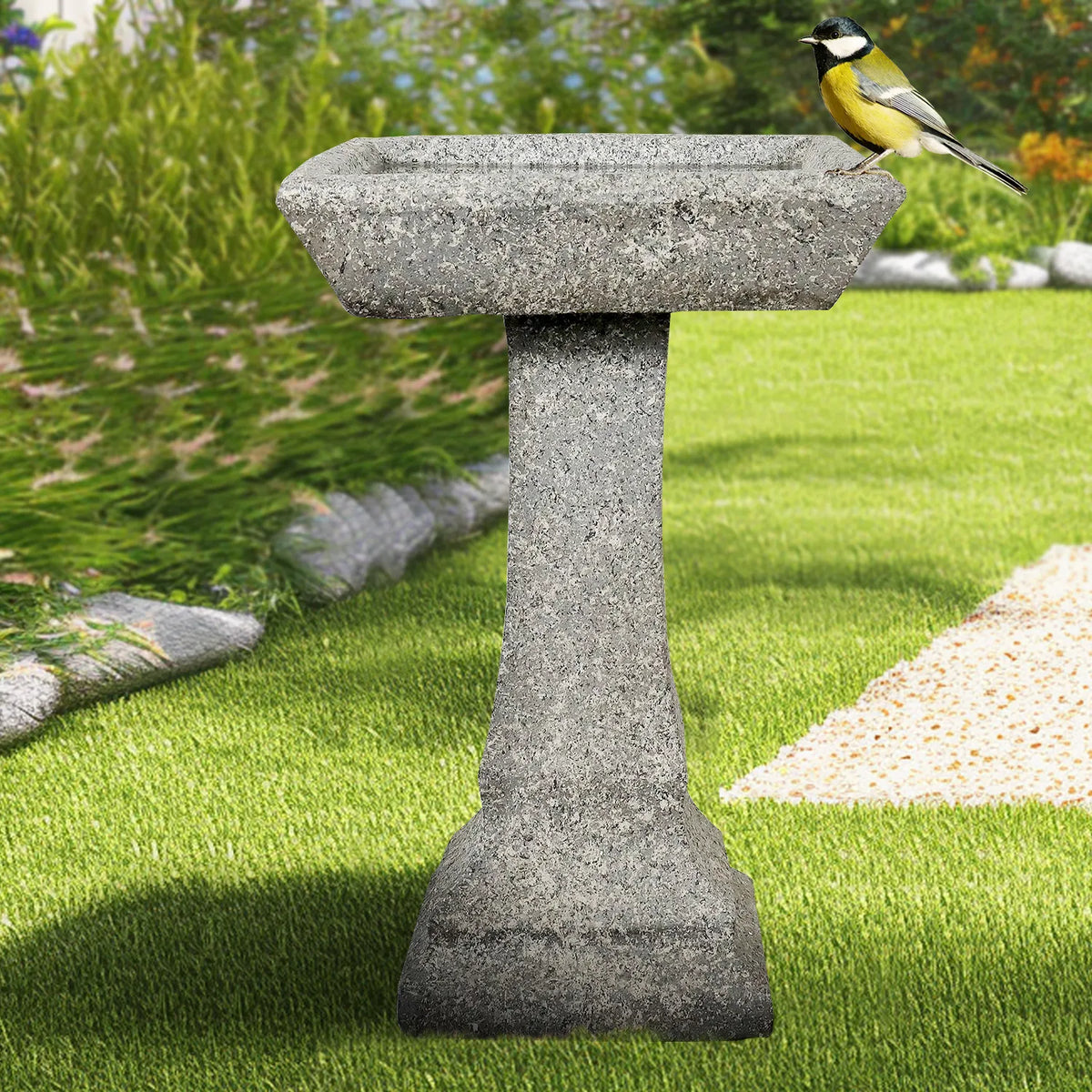 Modern fiber reinforced concrete birdbath on a fresh green lawn
