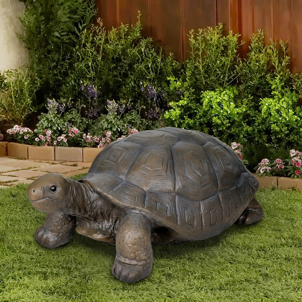 29.5" long dark gray concrete sea turtle statue resting in a garden
