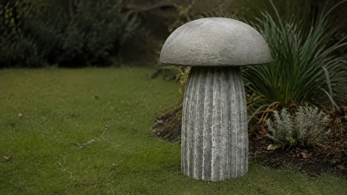 An upside down concrete bird bath bowl resting on its pedestal with no birds around