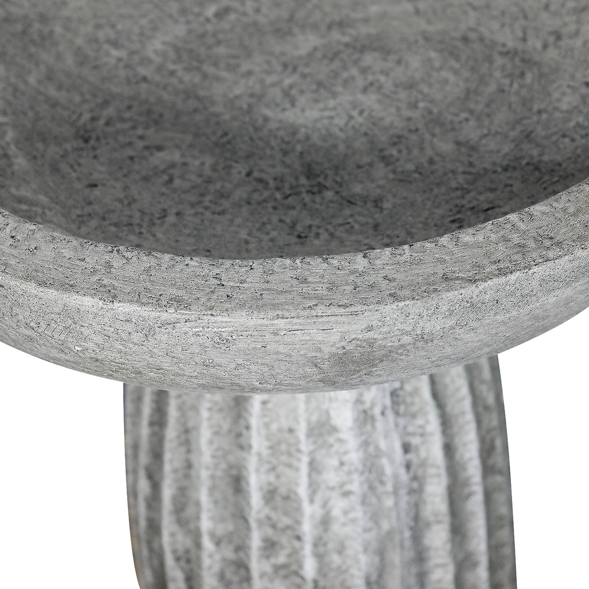 Close-up of shallow concrete bird bath basin rim with natural matte gray finish
