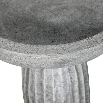 Close-up of shallow concrete bird bath basin rim with natural matte gray finish
