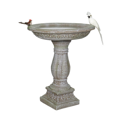 Front view of the antique pedestal concrete birdbath featuring a bird figurine on white