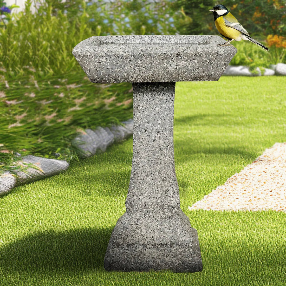 Modern fiber reinforced concrete birdbath on a fresh green lawn