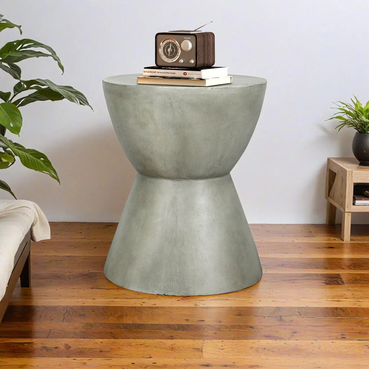 Symmetrical hourglass concrete end table used in a contemporary living room with wood flooring.