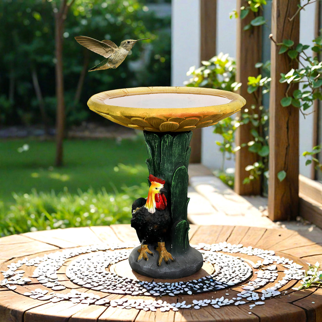 The sunflower and rooster concrete bird bath acting as a decorative centerpiece on a front yard patio.