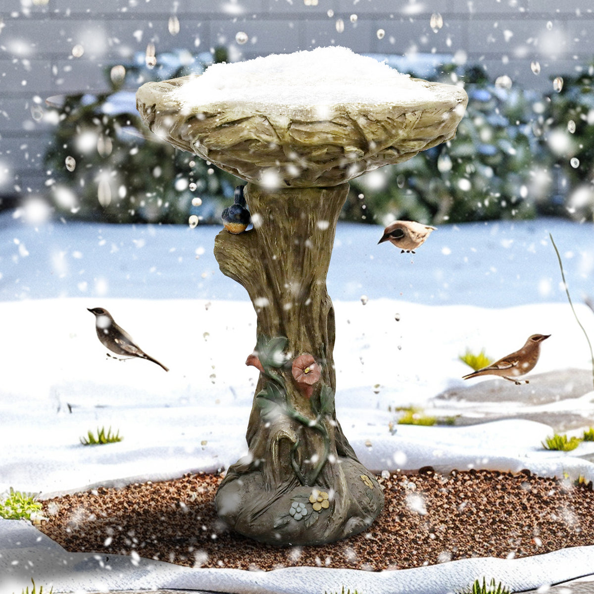Weatherproof 14.5kg concrete bird bath withstanding snow in a winter garden, attracting wild birds.