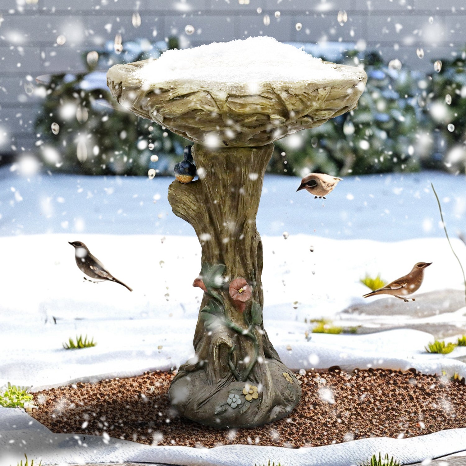 Weatherproof 14.5kg concrete bird bath withstanding snow in a winter garden, attracting wild birds.