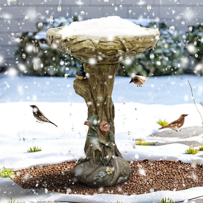 Weatherproof 14.5kg concrete bird bath withstanding snow in a winter garden, attracting wild birds.