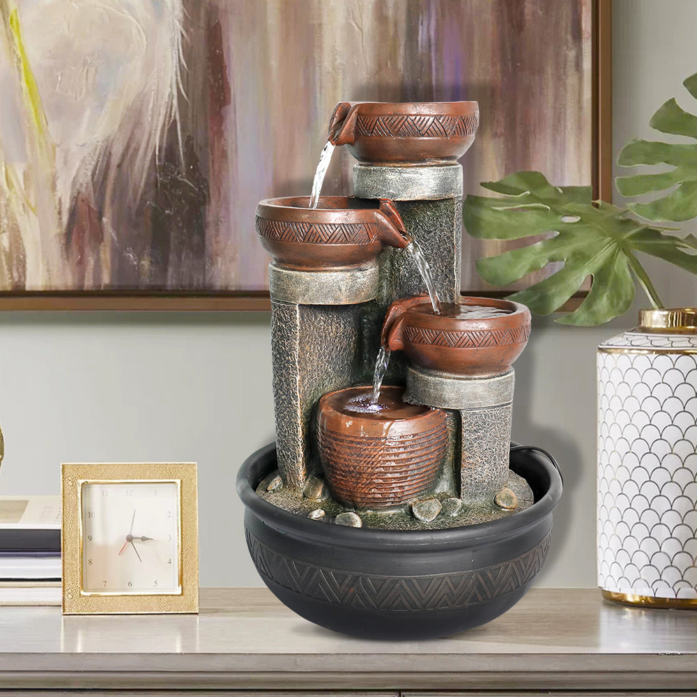Engraved bowls with four pouring spouts and warm lighting.